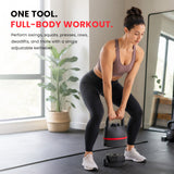 Woman performing a kettlebell deadlift in a bright home gym