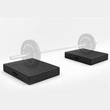 Pair of black MotionGrey weightlifting drop pads supporting a barbell