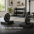 Loaded barbell resting on two MotionGrey drop pads in a home gym