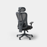 Black ergonomic mesh office chair from a rear three-quarter angle