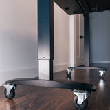 Lockable casters installed on a standing desk base