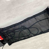 Close-up of cords stored inside a black under-desk mesh cable net