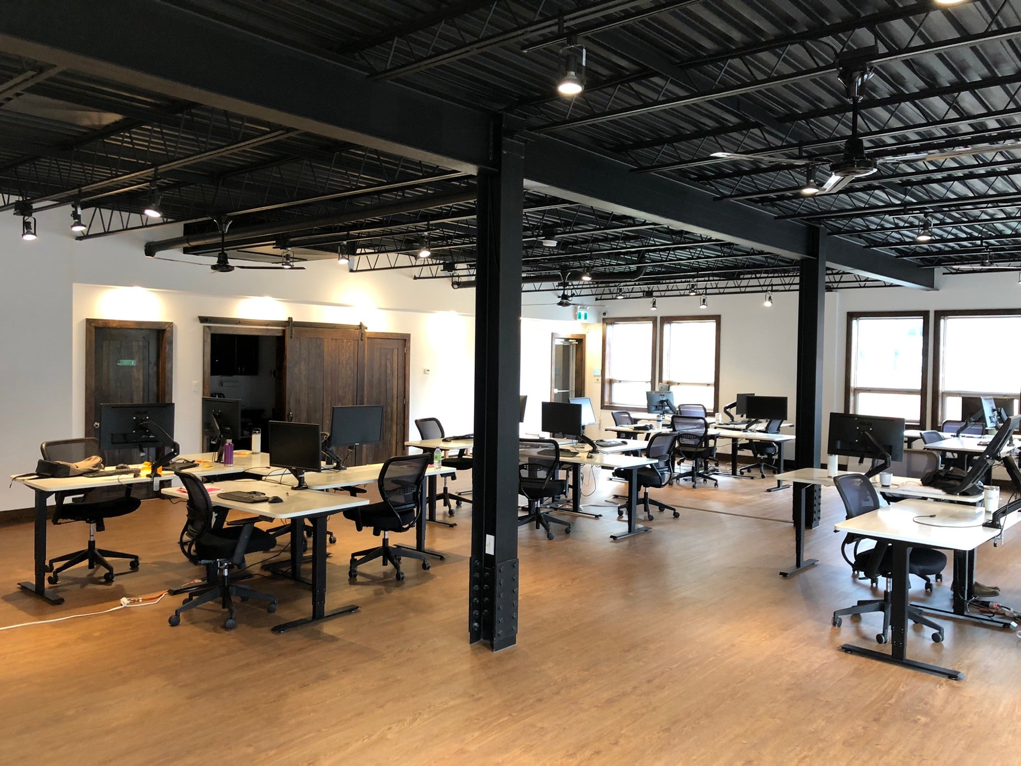 Motion Series standing desks and black SkyMesh office chairs in an open-plan software company office in Gatineau, QC.